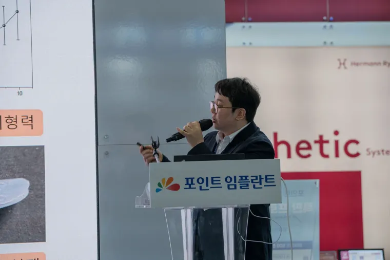 포인트 임플란트 부스 연단에서 강연하는 김교락 대표원장
